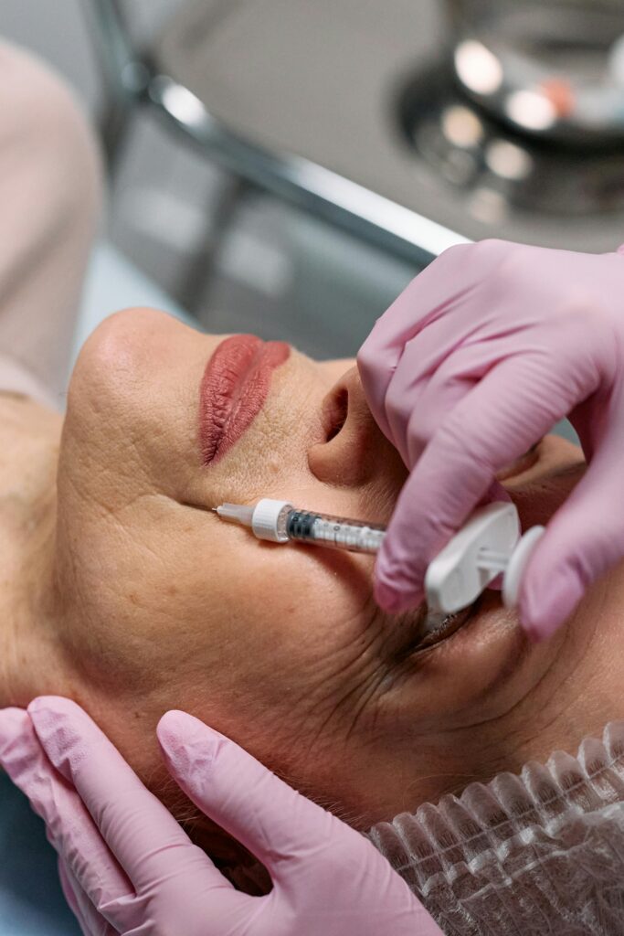 Close-up of a beautician administering a Botox injection to a woman at a clinic.